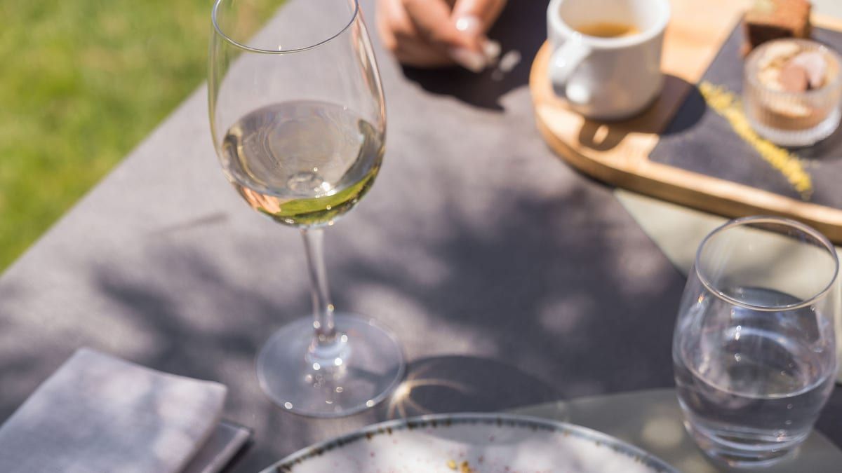 Un verre de vin blanc suisse et une assiette en terrasse